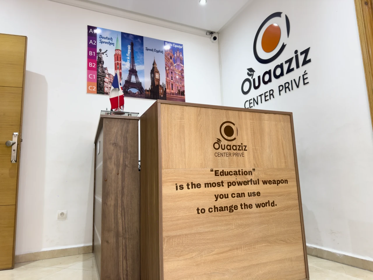 L’accueil en bois et les affiches de langues sur le mur.