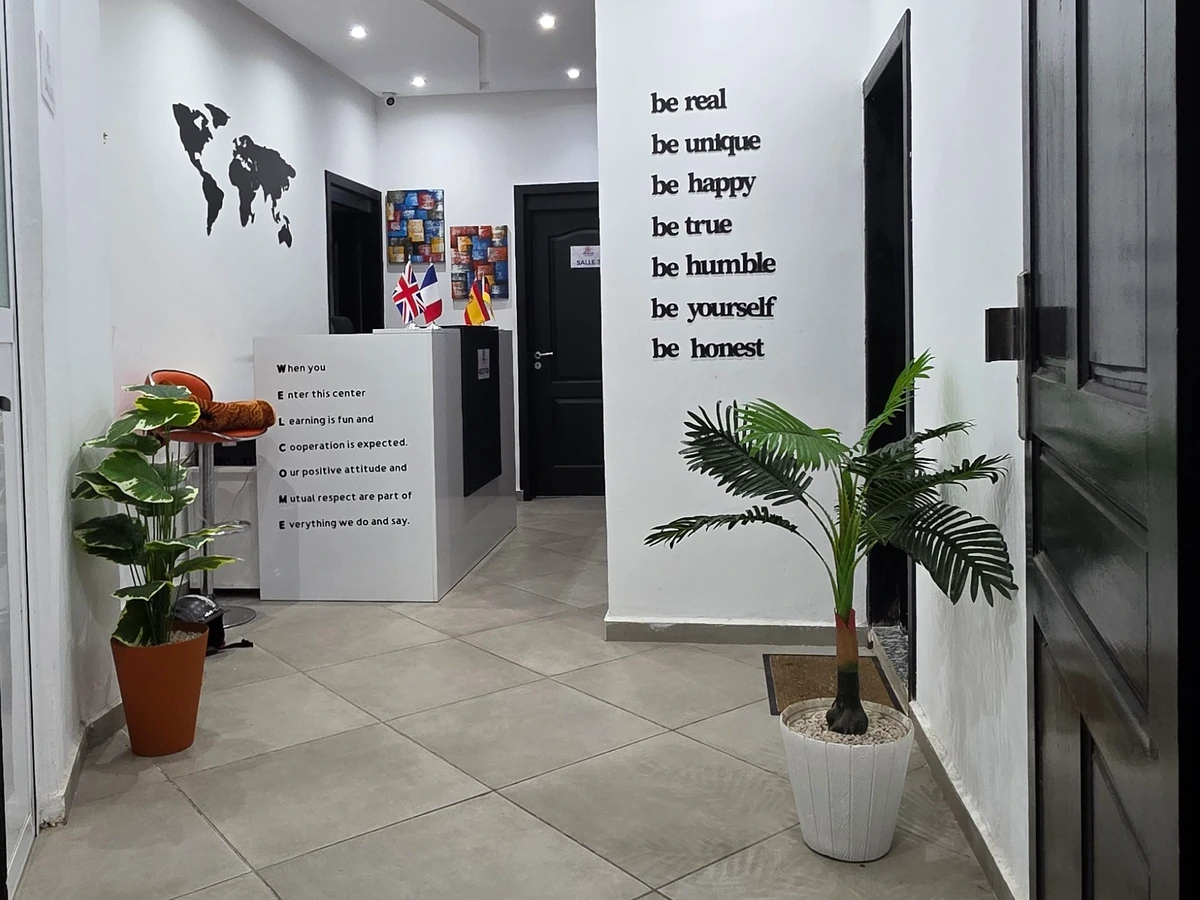 L’entrée du centre, avec le comptoir d’accueil, les drapeaux et les plantes.