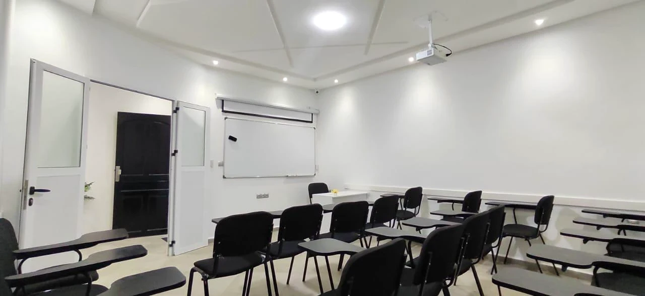 Les rangées de chaises face au tableau et au vidéoprojecteur.