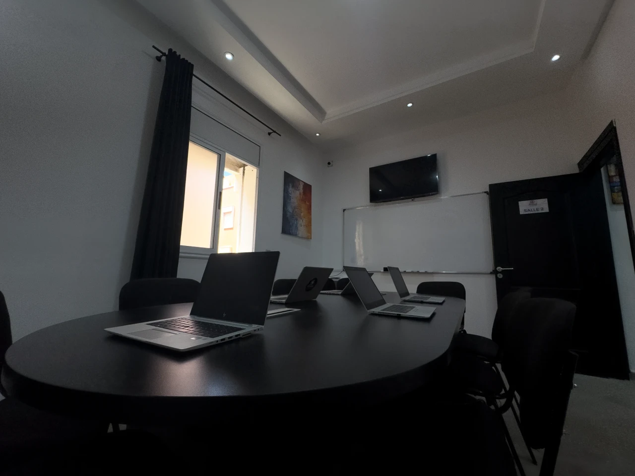 La table et les ordinateurs à la lumière de la fenêtre.