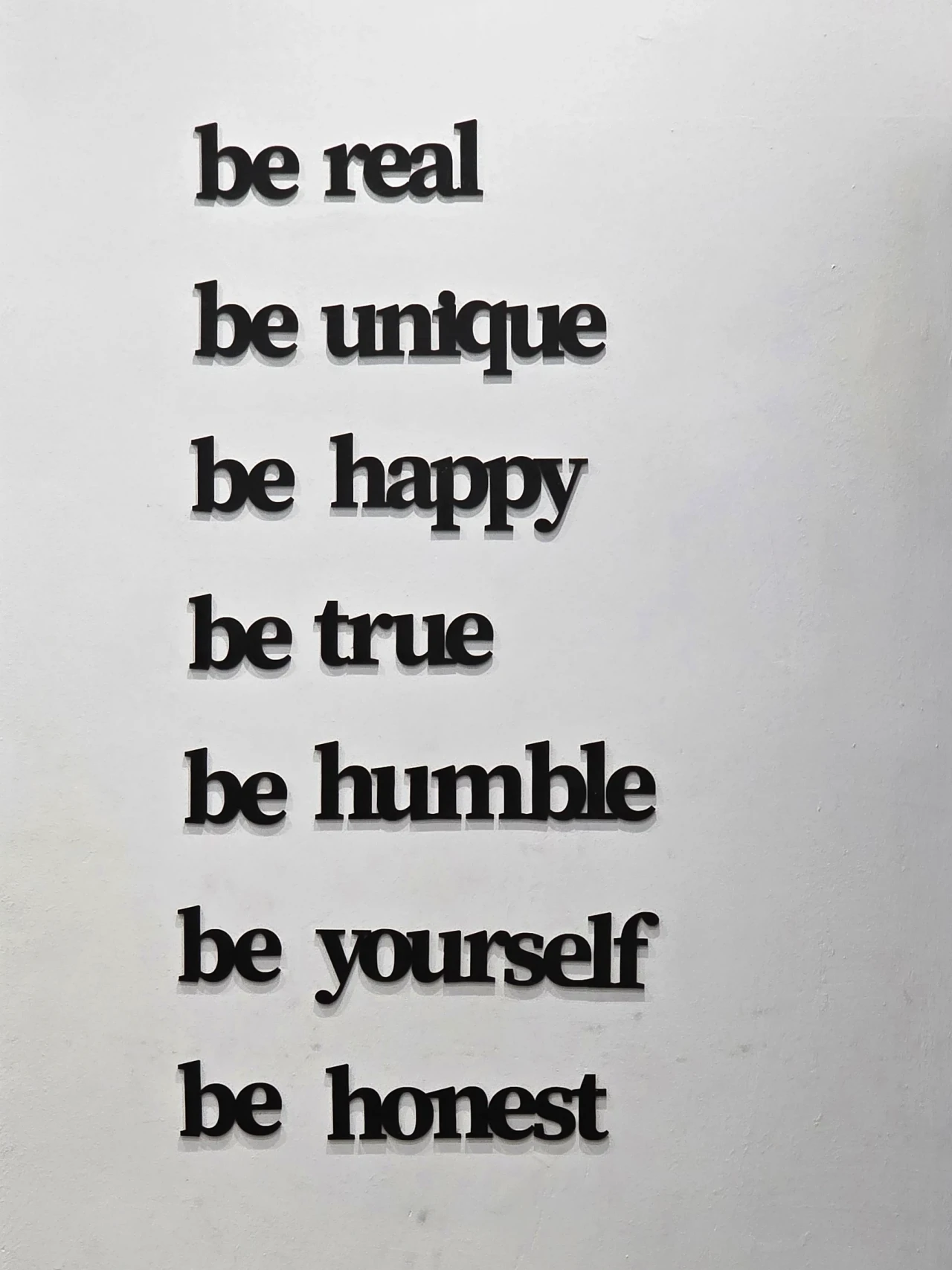 Les mots « be real, be unique » sur un mur du centre.