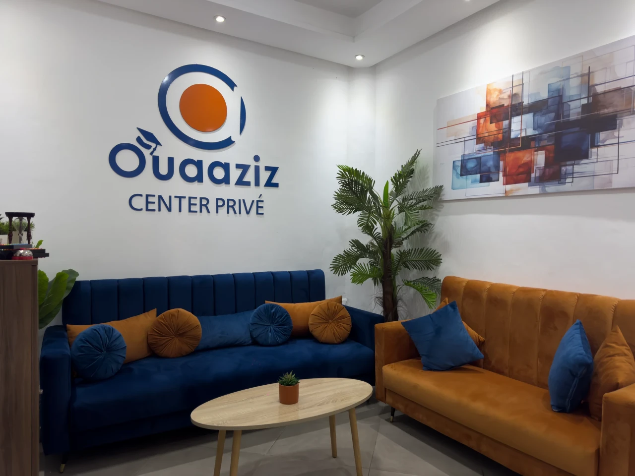 Les canapés de l’accueil sous le logo du centre.