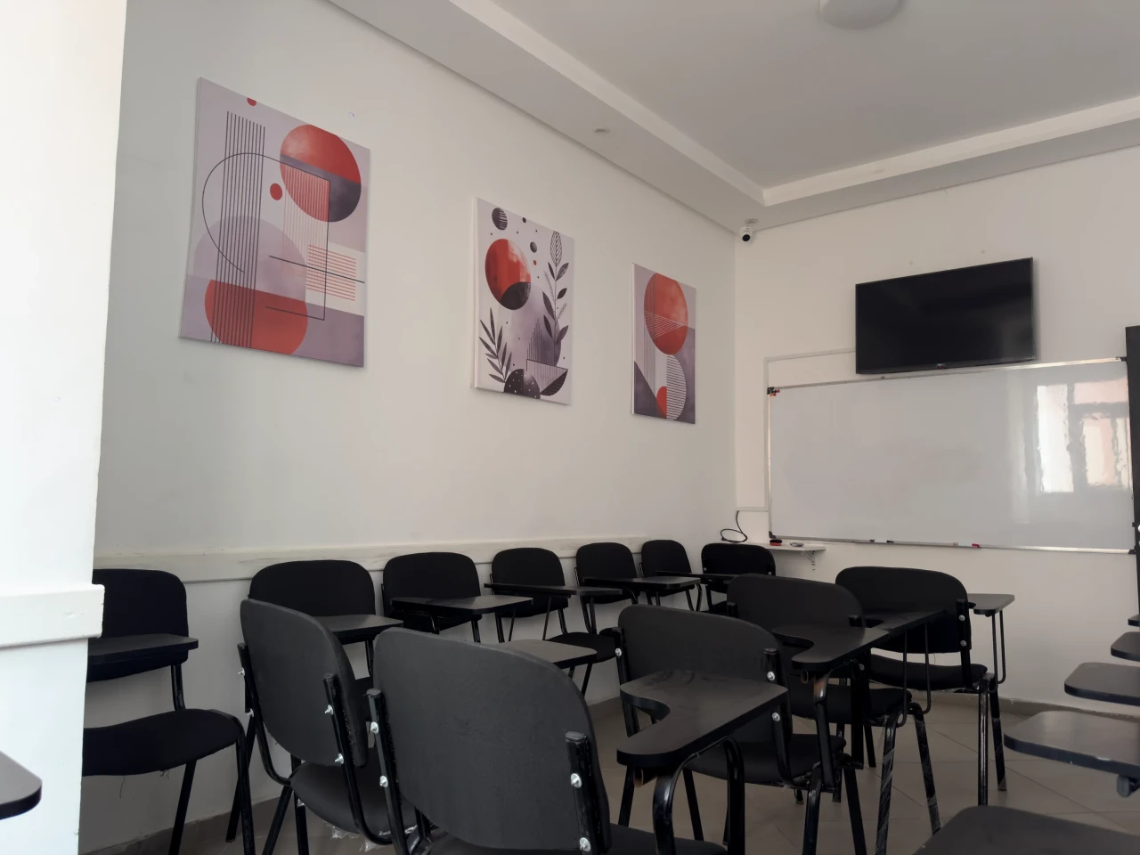 Une salle de cours, face au tableau et à l’écran.
