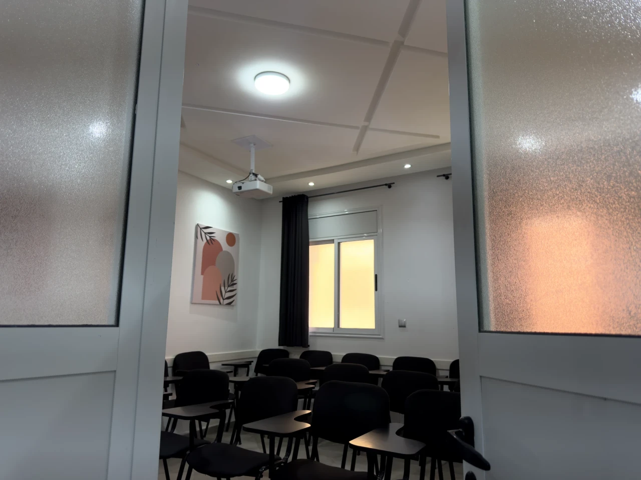 Une salle de cours vue à travers sa porte ouverte.