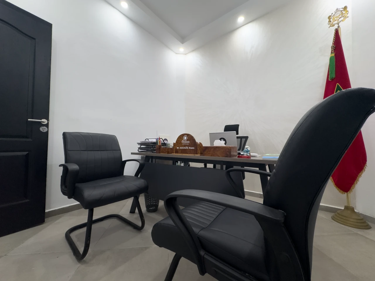 Un fauteuil visiteur devant le bureau de la direction.