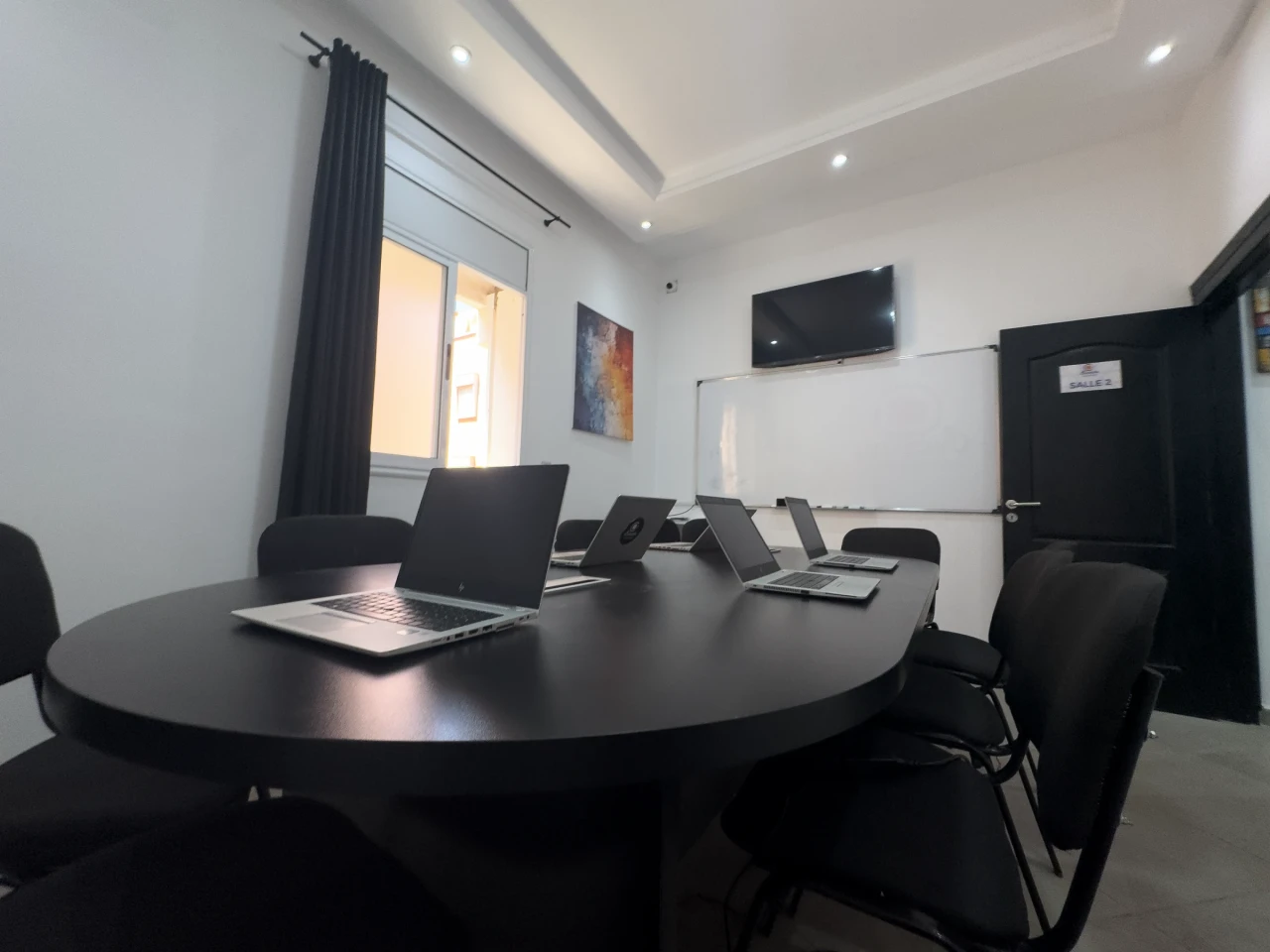 Un ordinateur au premier plan de la table de travail.