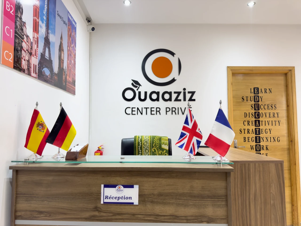 L’accueil en bois, avec les drapeaux et le logo mural.