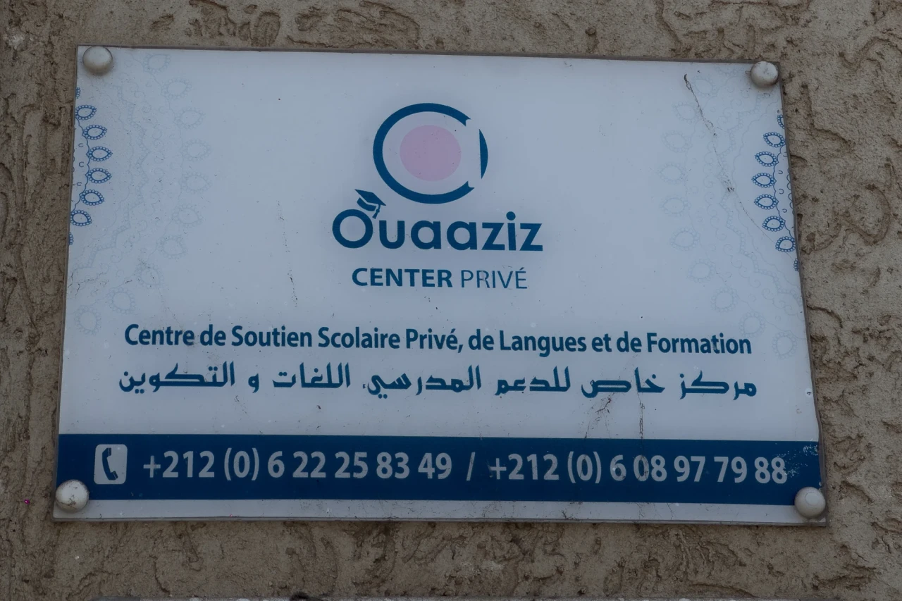 La plaque OUAAZIZ Center à l’entrée, avec les numéros de contact.