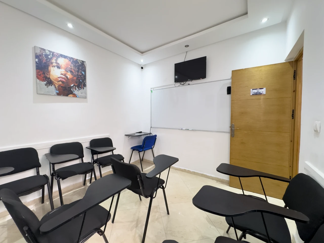 Le tableau et l’écran dans la salle à la porte en bois.