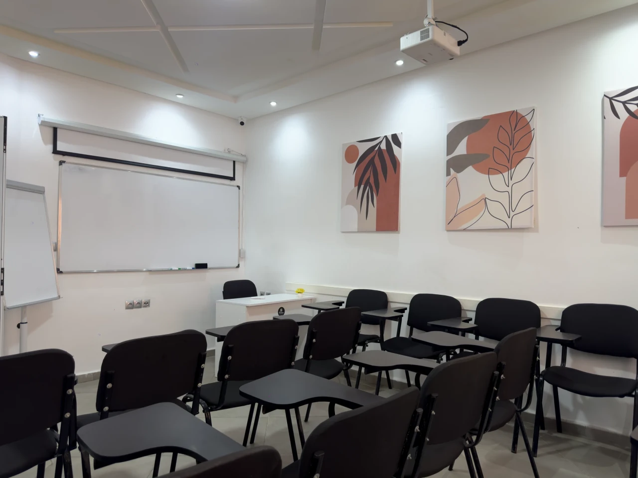 Le tableau et l’écran de projection de la salle.