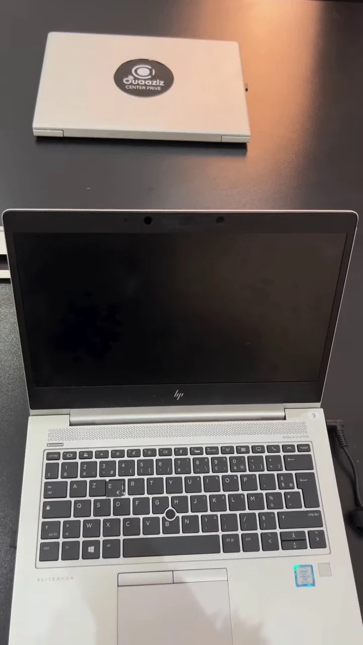 Deux ordinateurs portables du centre, dont un ouvert sur le clavier.