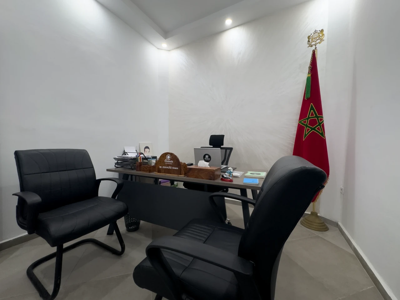 Le bureau de la direction et ses fauteuils noirs.